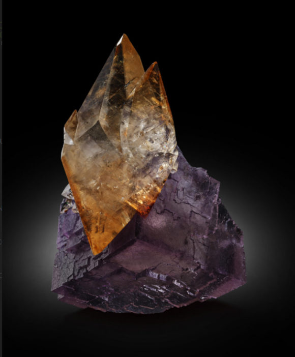 Big double terminated orange calcite crystal on a cubic purple crystal of fluorite from illinois cave in rock district